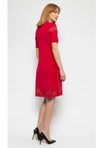 Czerwona, dzianinowa sukienka z krótkim rękawem, rozkloszowanym dołem oraz ozdobnymi przezroczystościami